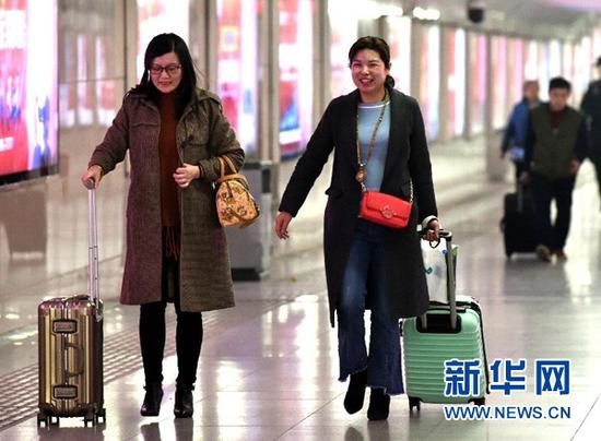 3月12日，两位旅客从郑州火车站出站。当日是2018年春运的最后一天，为期40天的2018年春运落下帷幕。 新华社发（李嘉南 摄）